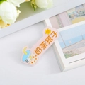 Detail shot of acrylic milk tea brooch with pink base and cute cartoon illustrations - Milk Tea Partner