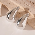 Macro-opname van zilveren druppeloorbellen met gepolijste spiegelglans op steen - Zilveren Acryl Druppel Oorknopjes / Zilver