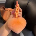 Close-up of peach orange faux fur heart keychain with matching thick link chain detail - Orange