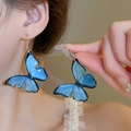 Makroaufnahme von zarten Ohrringen mit blauem Schmetterling am Ohr des Models - Ohrhaken-Stil (1#) / Blau