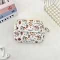 Flat lay of a white quilted cartoon coin purse with cat prints and a metal zipper hook - Cat Angel