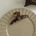 Detailed view of a large acetate claw clip with dark leopard print on a ceramic plate - Medium Hanger Style (No Label)