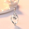 Dettaglio macro di una collana con ciondolo a torsione geometrica e zircone scintillante - Oro bianco