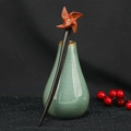Detail of a vintage sandalwood hair stick with a windmill head in a celadon vase - Windmill Shape (F2023776)