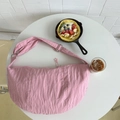 Pink crescent dumpling bag on a white table with brunch items for a casual lifestyle vibe - Pink