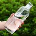 Transparent high borosilicate glass water bottle with time markers held in hand outdoors - 650ml / Clear