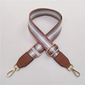 Close-up of adjustable striped fabric bag strap with golden metal hooks and PU leather - Pink Brown