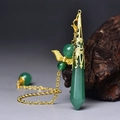 Macro detail of hexagonal green gemstone pendant with gold filigree cap on dark wood - Gold Green Aventurine