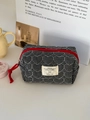 Detail of heart-quilted black and white checkered bag with a vibrant red zipper pull - Black