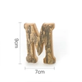 Rustic 9x7cm wooden letter M decoration featuring natural bark finish and solid wood base - Letter M