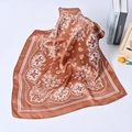 Close-up of brown silk scarf with white paisley patterns artfully folded on white table - Brown Paisley