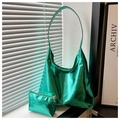 Grande borsa tote verde lucida con pochette coordinata su un davanzale con luce naturale - Verde