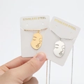 Detalle de collares de cara abstracta en acero inoxidable chapado en oro 18K y plata - Cara / Dorado