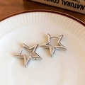 Close-up of star-shaped silver hoop earrings placed on a white ceramic tray with red rim - Ear Buckle / Silver