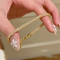 Detail eines goldenen Armbands mit funkelndem Zirkonia-Pavé am Handgelenk - Pave Strass (S845 Gold) / Gold