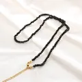 Collana chic con perline nere sfaccettate e chiusura dorata su sfondo di seta bianca - Nero