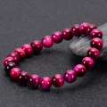 Fuchsia tiger eye beaded bracelet with chatoyancy effect on textured black surface - Natural Rose Red Tiger Eye / 6mm