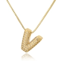 Macro detail of gold capital letter V pendant with cubic zirconia on a box chain - Letter V
