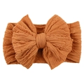 Macro shot of knitted caramel baby headband featuring a large textured bow detail - Coffee