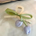 Close-up of a cream hair claw with green satin bow and lilac fabric tulip flowers - Purple Tulip Style
