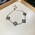 Macro shot of silver-toned clover bracelet featuring black motifs and adjustable slide clasp - Black