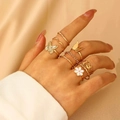 Detailed close-up of gold vintage floral and butterfly rings set on wrinkled fabric - Gold Style Set (5365) / KC Gold