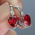 Macro shot of silver stud earring with heart-cut red gemstone and clear accents - Platinum Plated Red Zirconia