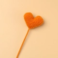 Nahaufnahme eines orangefarbenen Häkelherzens mit handgefertigter Stricktextur auf Rosa - Orange (Orangefarbenes Herz Einzelstück)