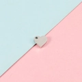 Detalle de pequeños dijes de corazón en acero inoxidable con agujero para joyería DIY - Color Acero