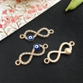 Three gold infinity charms with blue evil eye patterns and sparkly crystal rhinestones - KC Gold Evil Eye 10x29mm