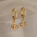 Orecchini a cerchio dorati con pendente a cuore rosa e zirconi in vista macro professionale - Stile Cuore (44531)
