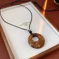 Detail of amber resin ring pendant with leopard cloud texture on black cord necklace - 2# Amber Round Peace Buckle Pendant Necklace
