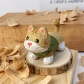 Macro shot of hand-carved wooden cat figurine with visible chisel textures on a wood base - Orange Striped Style (Xiao Jin)
