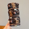 Brown hair tie set featuring heart charms and smiley face tags in a clear box - Brown