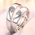 Close-up of silver-plated couple rings forming a heart shape with small crystals - Men / Heart Puzzle