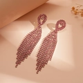 Dettaglio di eleganti orecchini a nappa rosa con strass scintillanti e perno a goccia - Rosa