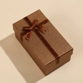 Vista dettagliata della confezione regalo marrone scuro con fiocco e finitura testurizzata - 14x8x6cm / Marrone