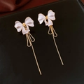 Detail of white bow earrings with golden tassels and delicate metal textures - Gold-White Bowknot