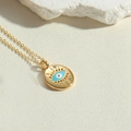 Detailansicht der goldenen Evil Eye Anhänger Halskette auf beigem Hintergrund - Ovaler Anhänger Böser Blick (XL2982-4)