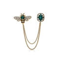Broche abeille vintage dorée avec pierres émeraude et chaînes sur fond blanc neutre - Or Vintage - Petite Abeille