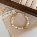 Macro view of freshwater pearl bracelet with gold beads and a spherical pendant detail - Freshwater Pearl Gold Ball Pendant Bracelet