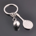 Silver metal tennis racket and ball keychain accessory on a black reflective background - Tennis Racket Style (GX-297)