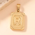 Macro detail of gold stainless steel rectangular pendant featuring embossed letter R and texture - Letter R