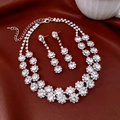 Detailansicht der funkelnden Strass-Halskette und Ohrringe auf rotem Satinhintergrund - Halsketten- und Ohrring-Set / Silber-Weiß