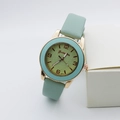 Détail de montre à quartz vert menthe avec boîtier en or rose et cadran texturé - vert clair