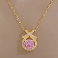 Close-up of golden bow pendant with a round pink stone and sparkling micro-diamonds - Pink Gemstone Bowknot Necklace (D131)