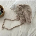 Close-up of beige chunky knit monster hat with woven ties on soft white background - One Size / Versatile Beige