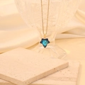 Detailed close-up of a blue star crystal pendant on a gold chain over white silk fabric - Royal Blue
