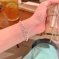 Double-layered bracelet featuring pearls and a silver bow pendant with zircon details - S598 Silver