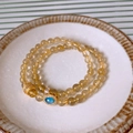 Detailaufnahme des doppellagigen Perlenarmbands mit Haarkristall und blauem Zirkon - Goldgelb (Blauer Anhänger)